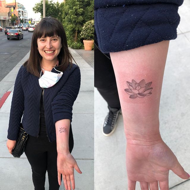 Allison Raskin showing tattoo wearing black pant, black shirt and blue jacket